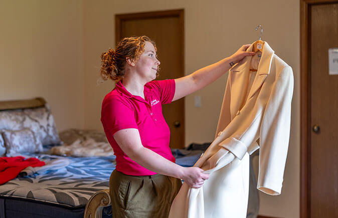 Employee holding up a coat